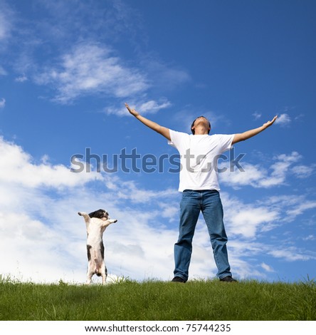 young man relax on the green field with his dog