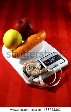 Fruits and Vegetable on a Weighing Scale with a Measuring Tape A photo of fruits and vegetable on a weighing scale with a measuring tape