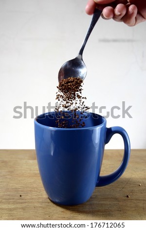 Coffee Being Poured To a Mug Photo of coffee grains being poured to a blue mug.