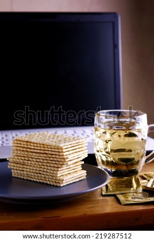 Soda Crackers, cup of tea and a computer Photo of a stack of soda crackers, cup of tea and a computer