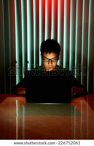 Young Teen with eyeglasses in front of a laptop computer Photo of a Young Teen with eyeglasses in front of a laptop computer