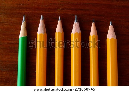 Four yellow pencils and one green pencil Photo of Four yellow pencils and one green pencil