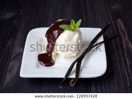 Vanilla ice cream with chocolate syrup and vanilla sticks