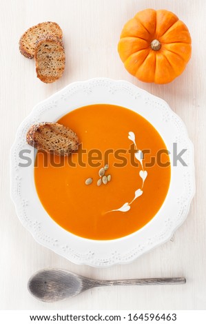 Pumpkin soup with croutons and pumpkin seeds in a white plate