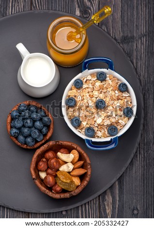 Oat flakes, blueberries, nuts, honey and milk. Fitness breakfast.