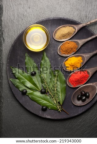 Spices, herbs and olive oil on vintage background