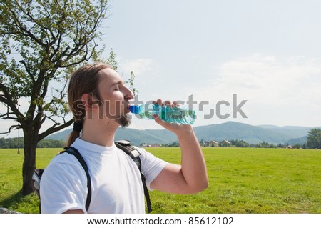 man drinking water in mountains