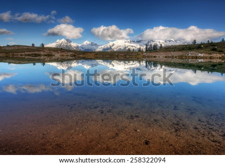 Clear waters with distant mountains and evergreen trees