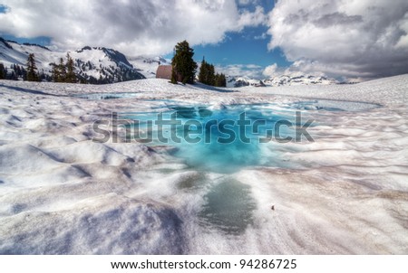 Brilliantly blue melt pool on top of snow