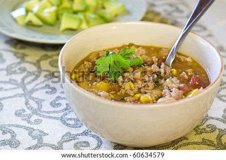 Bowl of Low Calorie White Bean Turkey Chili Topped with Cilantro and Avocado