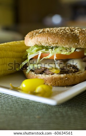 Spicy Italian Beef Sandwich on a Toasted Whole Wheat Bun with Peperoncini Peppers and Corn on the Cob