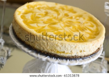 Whole Swirled Mango Cheesecake on a White Flowered Cakeplate