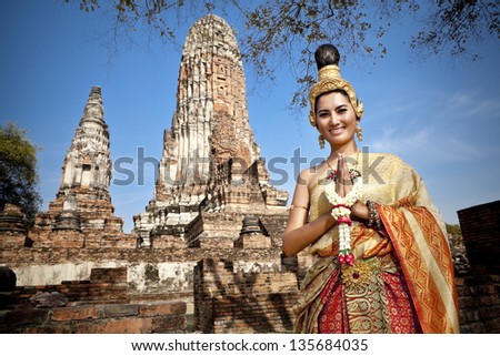 woman performing typical thai dance with thai style temple background, identity culture of thailand