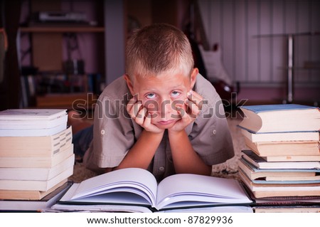 ten year old boy reading book, tired of learning process