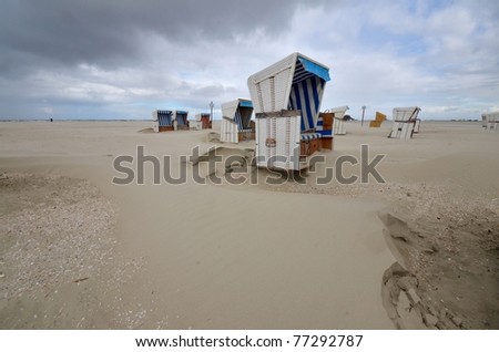 beach of St. Peter Ording at the german Atlantic coast with hooded beach chairs