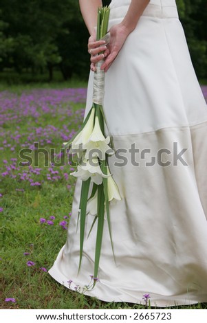 Bride standing in flower field holding her bouquet