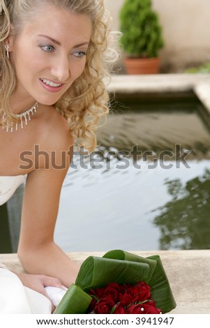 A bride on her wedding day next to a little pond
