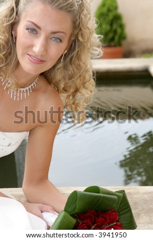 A bride on her wedding day next to a little pond