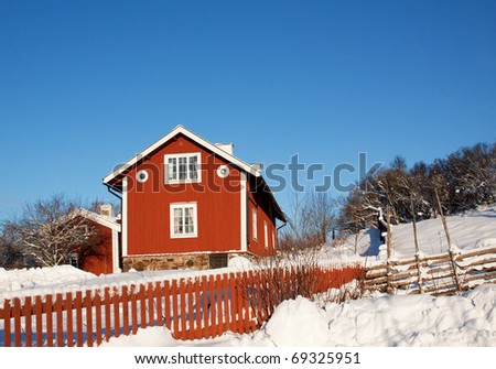 Idyllic cottage in sweden at winter time,   a lot of snow,  old fence  and chimney.