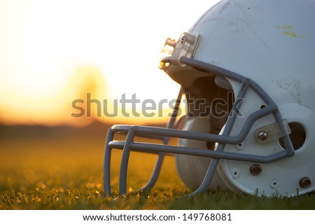 American Football Helmet on the Field at Sunset with room for copy