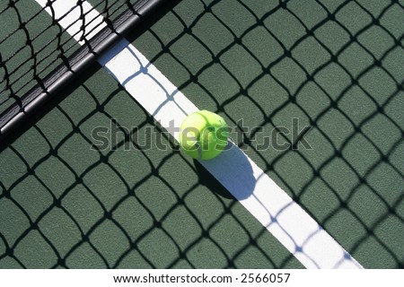 Tennis ball in the shadow of the net