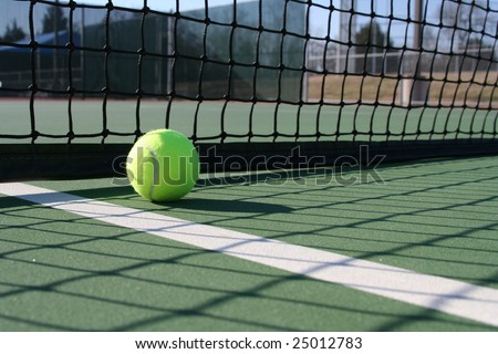Tennis ball in the shadow if the court net