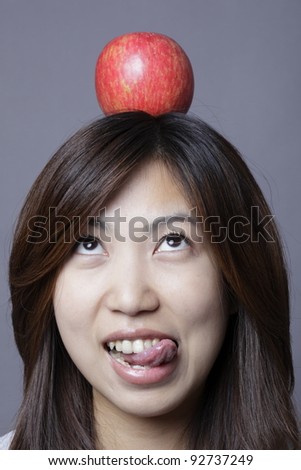Office lady has apple on the top of head.