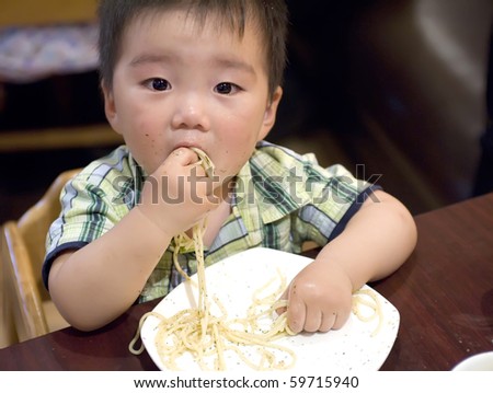 a eating baby to grab pasta