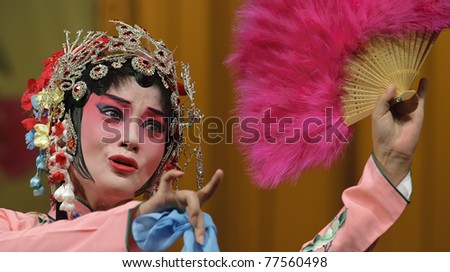pretty Chinese opera actress performs traditional drama on stage