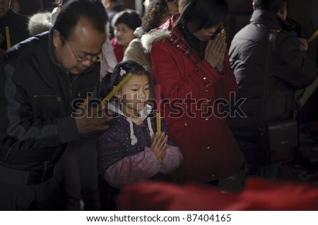 CHENGDU - FEB 14: Crowded people kneel down and praying to Buddha in temple during chinese new year on Feb 14, 2010 in Chengdu, China. It\'s part of the important traditional custom in China.