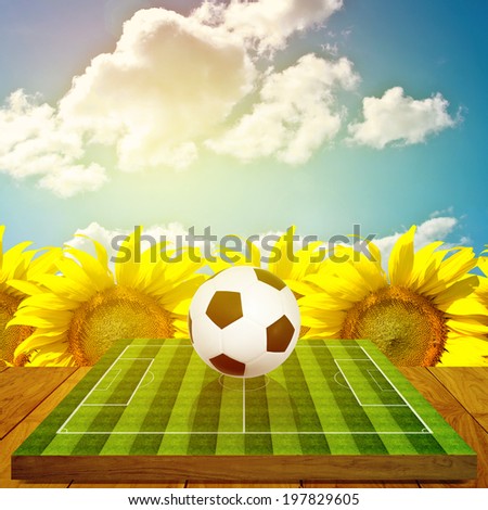 Ball on soccer field board game with sunflower farm background, Summer sport concept