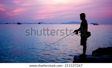 Silhouette of fishing man beside the sea