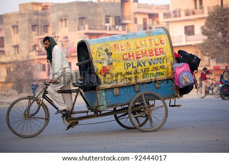 NEW DELHI, INDIA - JANUARY 23: Indian man drives kids to school on Republic Day on January 23, 2011 in New Delhi, India. Republic Day commemorates the date on which the constitution of India began.