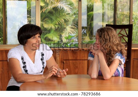 Two women share a conversation at the dining room table