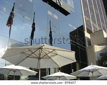 Umbrellas, flags, reflection at a cafe across from old world trade center