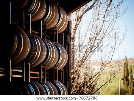 Large French Oak Wine Barrels stacked near a roll up door at a winery in paso robles