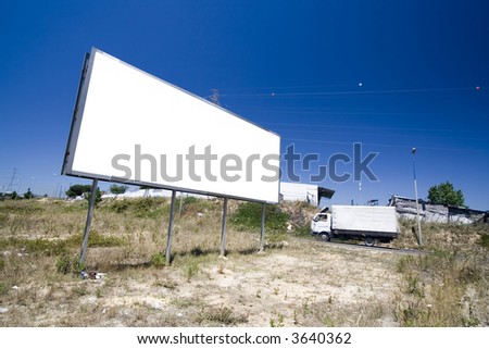 Giant billboard near a public road with cars passing by