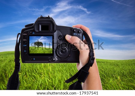 Woman photographing landscape with digital photo camera