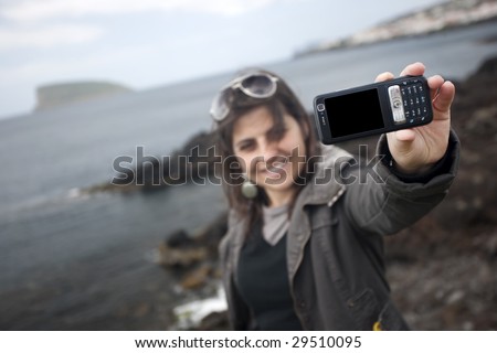 young woman taking self portrait with mobile phone camera - travel concept