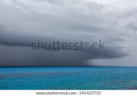 A severe thunderstorm over the ocean off the coast of Bermuda. The anvil shaped cumulonimbus incus clouds are seen with rain falling.