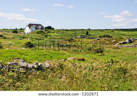 A single house in a green field. Location is Galway, Ireland.