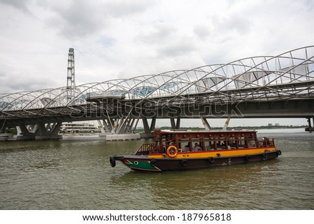 SINGAPORE - NOVEMBER 05, 2012: Tourist boat with tourists moving along the Singapore River. The Singapore River Cruise is one of the main tourist attractions of this exotic city.