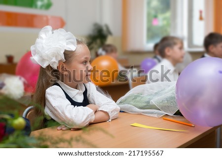 First grader girl in the first day of school in the classroom. Russia.