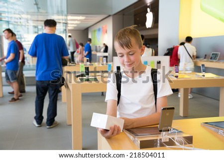HONG KONG, CHINA - JUNE 18, 2014: Boy looks at the packaging at Apple store in Hong Kong. Store is in a shopping center IFC Mall, it is very popular with locals and tourists visiting Hong Kong.