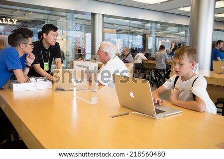 HONG KONG, CHINA - JUNE 18, 2014: Buyers and shop assistants at Apple store in Hong Kong. Store is in a shopping center IFC Mall, it is very popular with locals and tourists visiting Hong Kong.