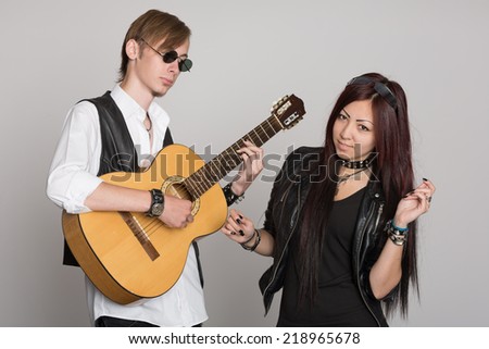 Young musicians play and sing on the guitar. Interracial young couple, Asian woman and Caucasian man.