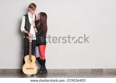 Young man and woman standing at the wall. Interracial young couple, Asian woman and Caucasian man.