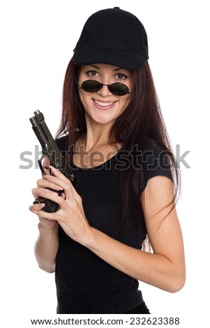 Smiling young woman in a black baseball cap with a gun.