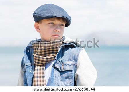 Boy with a serious look looking away against the background of the sea. 11 years old.