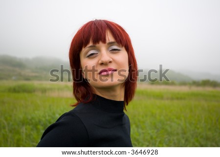 The fine girl with an easy smile on a background of a fog.